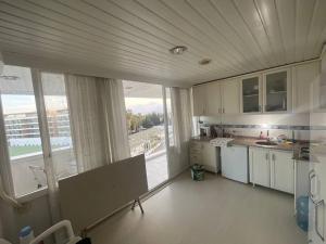eine Küche mit weißen Schränken und einem großen Fenster in der Unterkunft Lovely Private Flat For Two People in Antalya