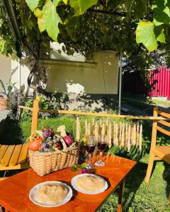 a table with glasses of wine and a basket of food at Guest house rainbow in Surami