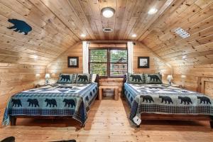 a bedroom with two beds in a log cabin at Epic Mountain Views, Hot Tub, Game Room, Sleeps 10 in Sevierville