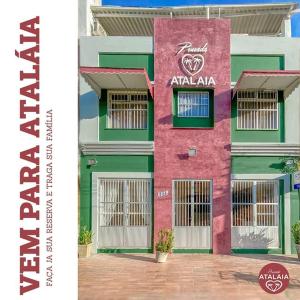 a pink and green building with aania sign on it at Pousada atalaia ll in Fortaleza