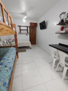 a room with a bunk bed and a table and chairs at Cantinho do sossego na praia grande Ubatuba in Ubatuba