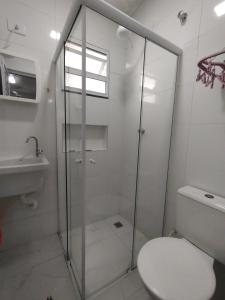 a bathroom with a shower and a toilet and a sink at Cantinho do sossego na praia grande Ubatuba in Ubatuba