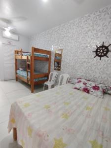 a bedroom with a bed and two bunk beds at Cantinho do sossego na praia grande Ubatuba in Ubatuba