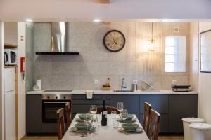 a kitchen with a table and a clock on the wall at 1884 Aveiro Loft in Aveiro