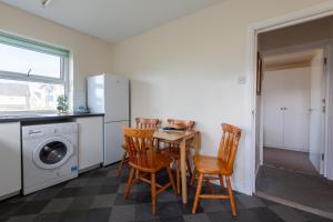 a kitchen with a table and chairs and a refrigerator at 13 Victoria Road Apartment in Cardiff