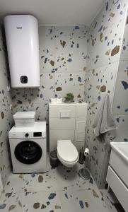 ein Badezimmer mit einem WC und einer Waschmaschine in der Unterkunft Apartman G6 in Bjelovar