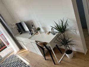 einen weißen Schreibtisch mit Topfpflanze in einem Zimmer in der Unterkunft Apartman G6 in Bjelovar