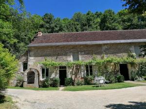 an old stone house with a table in front of it at Le moulin du Mesnil in Saint-Georges-sur-Cher
