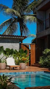 uma piscina com uma cadeira e uma palmeira em Vila Sal Boutique Noronha em Fernando de Noronha
