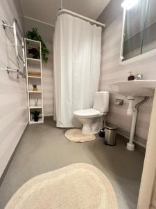 a bathroom with a white toilet and a sink at Noah Longstay Borås in Borås