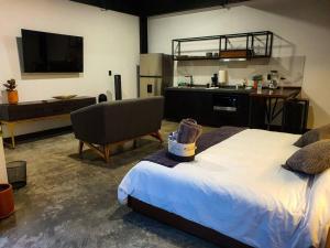 a bedroom with a large bed and a kitchen at Loft Bronce en excelente ubicación! in San Luis Potosí