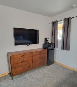 a living room with a flat screen tv and a dresser at Topaz Lodge in Buena Vista