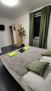 a bedroom with a large bed with green pillows at Apartmány u golfu in Jihlava