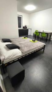 a large bed in a room with green chairs at Apartmány u golfu in Jihlava
