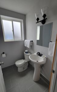 a white bathroom with a toilet and a sink at Topaz Lodge in Buena Vista