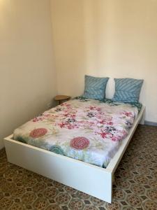 uma cama com um edredão floral num quarto em Maison au cœur de la Ville. em Saint-Gilles