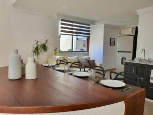 a dining room table with chairs and a living room at Hermoso departamento con excelente ubicación in San Luis Potosí