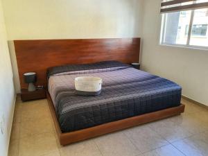 Un dormitorio con una cama con cabecero de madera. en Hermoso departamento con excelente ubicación, en San Luis Potosí 11 fotos más