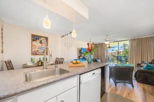 a kitchen with a sink and a living room at Maui Sunset B402 in Kihei