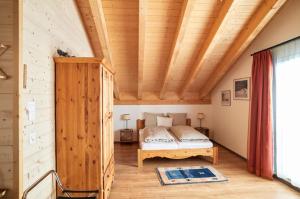 a bedroom with a bed in a wooden house at Hotel Harmony Tigilou Belalp in Belalp
