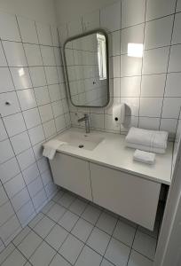 a white bathroom with a sink and a mirror at Farmer's Guest House in Hella