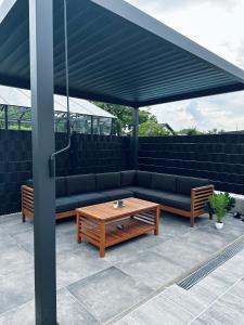 a patio with a couch and a table under a canopy at NewEra Apartment 1 