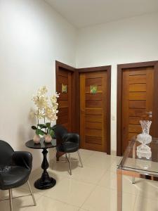a room with a table and chairs and wooden doors at Suites Silva in Capitólio
