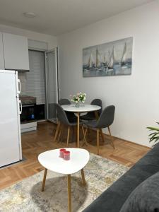 a living room with a table and chairs and a kitchen at House Inn 2 in Pirot