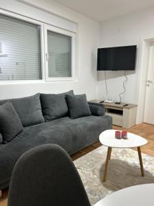 a living room with a gray couch and a table at House Inn 2 in Pirot