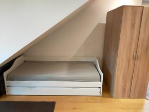 a bed under the stairs with a wooden cabinet at Zimmer 31qm inkl. Duschbad in Hamburg