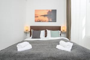 a bedroom with two white towels on a bed at Central City Apartments in Vienna