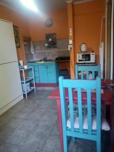 a kitchen with a table and a kitchen with blue cabinets at Lo de Guille in Oberá