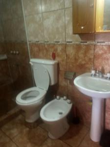 a bathroom with a toilet and a sink at Lo de Guille in Oberá