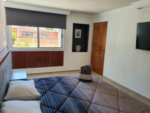 een kamer met een bed met 2 kussens en een raam bij Departamento con estilo y excelente ubicación in San Luis Potosí