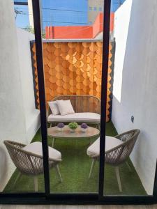 een balkon met 2 stoelen, een tafel en een bank bij Departamento con estilo y excelente ubicación in San Luis Potosí