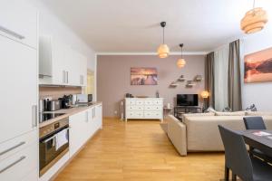 a kitchen and living room with a couch and a table at Central City Apartments in Vienna