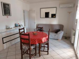 een keuken met een tafel en stoelen en een bank bij Gite des Reguinelles in Saint-Lattier