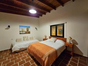 a bedroom with two beds and a window at Posada del Atelier in San Antonio de Areco