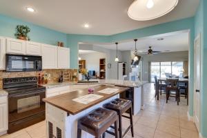 Gold CanyonにあるMtn Views Family-Friendly Gold Canyon Getaway!の白いキャビネットとカウンタートップ付きのキッチンアイランドが備わるアパートメントです。