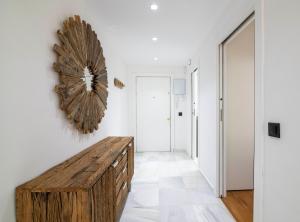 un pasillo con un banco de madera en una habitación blanca en Playa Del Duque Apartment Ocean Club 1, en Marbella