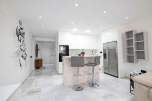 a kitchen with white walls and a white floor at Playa Del Duque Apartment Ocean Club 1 in Marbella