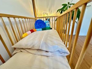 a crib with a pillow and a stuffed toy at Ferienwohnung Marion Klagenfurt zentrumsnähe in Klagenfurt