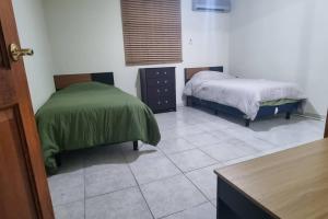 a bedroom with two beds and a tiled floor at Departamento Planta Baja para 6 in Tampico
