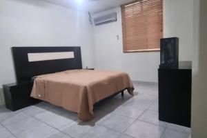 a bedroom with a bed and a flat screen tv at Departamento Planta Baja para 6 in Tampico