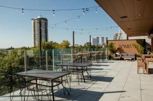 a patio with tables and chairs and a view of the city at Brut Hotel in Tulsa
