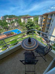 balcón con mesa, sillas y piscina en Penthouse Apartment with Spectacular Pool and Mountain Views!, en Jacó