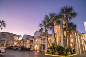 ein großes Gebäude mit Palmen auf einem Parkplatz in der Unterkunft Best Western Seaside Inn in Saint Augustine Beach