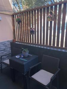 a table and two chairs on a patio with a fence at Katila-Rooms in Santa Maria