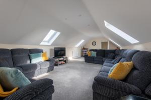 ein Wohnzimmer mit blauen Sofas und einem TV in der Unterkunft Seaview Cottage in Cardiff