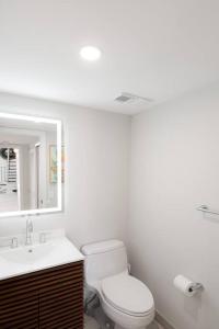 a bathroom with a toilet and a sink and a mirror at Villa at St James Unit A Luxury Pool Villa, Pet Friendly in Miami +10 photos